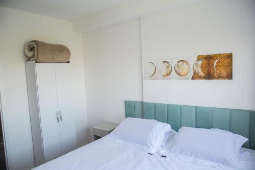 a bedroom with a bed and a painting on the wall at Areatricolor in Porto Alegre