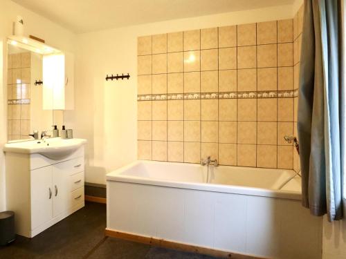 a bathroom with a white tub and a sink at Annexe in Sourbrodt