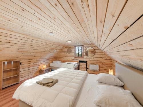 a large bed in a room with a wooden ceiling at ZweveZalig in Zwevezele