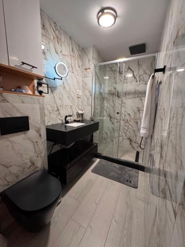 ein Badezimmer mit Dusche, Toilette und Waschbecken in der Unterkunft N3XT LEVEL home in Praia