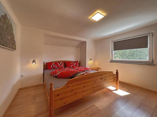 a bedroom with a bed with red pillows and a window at Zum wilden Jakob in Stadlern