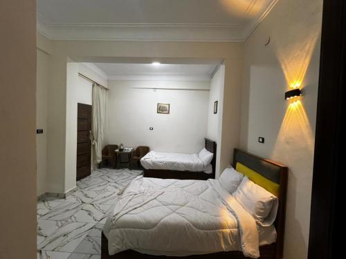 a hotel room with two beds in a bedroom at tulip pyramids iin in Nazlet el-Sîsi