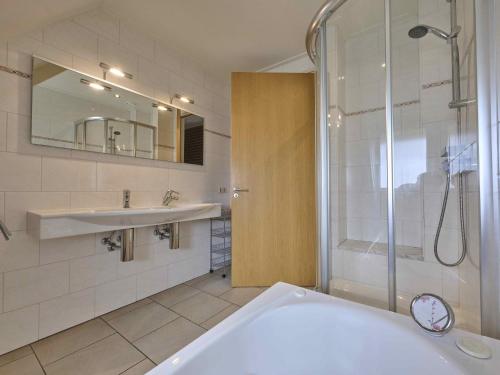 a bathroom with a tub and a sink and a shower at t Achterhoes in Neede