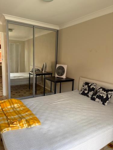 a bedroom with a large bed and a mirror at 海边度假屋 in Sydney