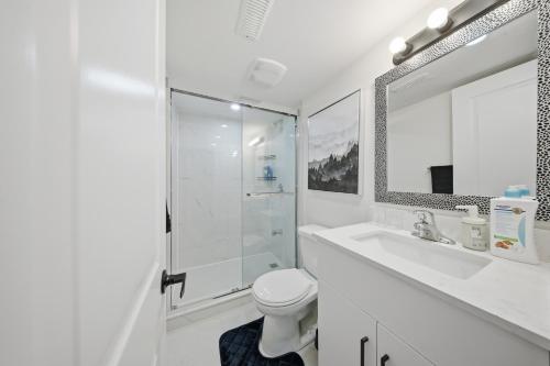 a white bathroom with a shower and a toilet at Caledon Quiet Luxury Escape 3BR Suite in Brampton