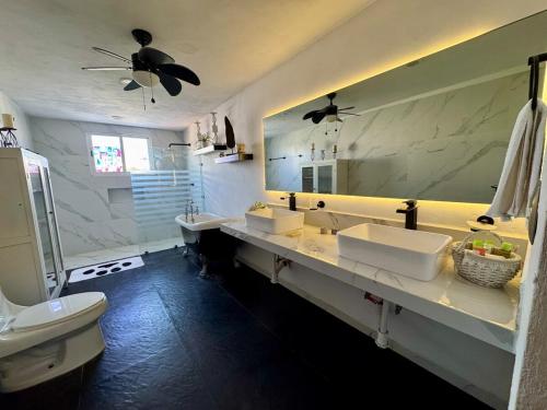 a bathroom with two sinks and a large mirror at Beautiful house with a pool in Mérida