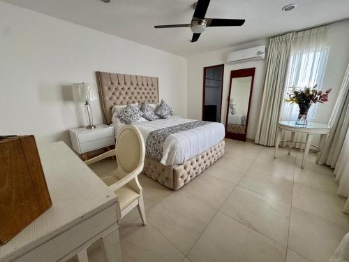 a bedroom with a bed and a table and a window at Beautiful house with a pool in Mérida