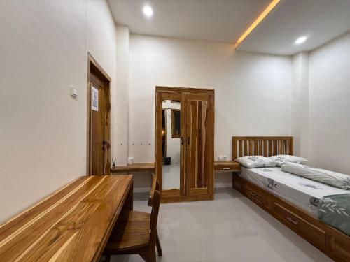 a bedroom with two beds and a wooden table at Salt & Light Labuan Bajo in Komodo Labuan Bajo Airport