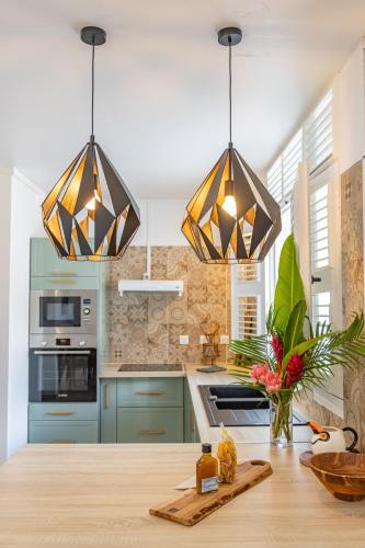 a kitchen with blue cabinets and three lights at Pointe Noire in Pointe-Noire