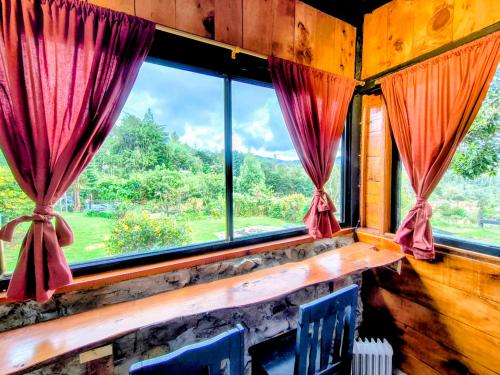 a room with a window with red curtains at Chalet Stonehenge in Pasto