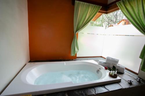 a bath tub in a bathroom with a window at Monterra Tapalpa in Tapalpa