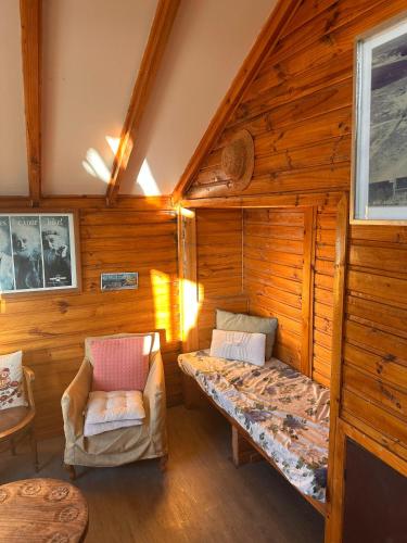 a bedroom with a bed and a chair in a cabin at Casa Almar in Algarrobo