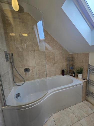 a large white bath tub in a bathroom at Gracian OMB Ongar 3 Bed in Dublin