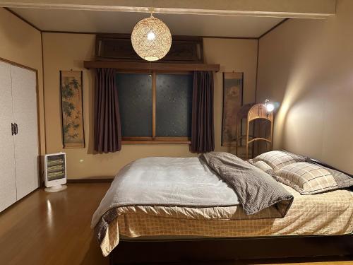 a bedroom with a bed in a room with a window at Nomad Gala Otaru in Otaru