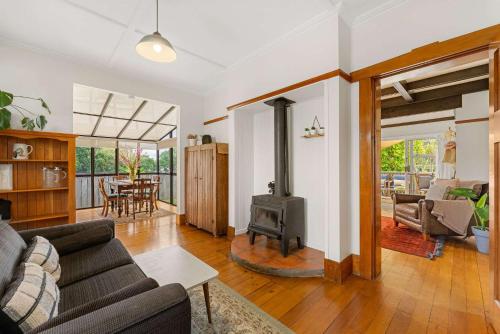 a living room with a couch and a wood stove at Cabbage Tree Cottage in Papamoa