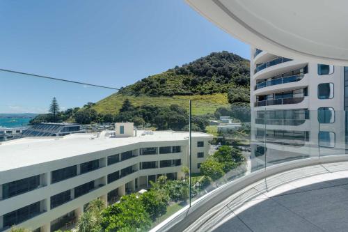 a view of a building with a mountain in the background at Oceanside Belle in Mount Maunganui