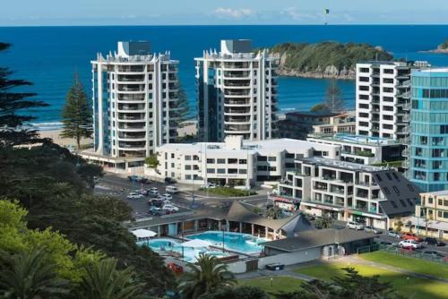 an aerial view of a city with buildings and the ocean at Executive Oceanside Apartment in Mount Maunganui
