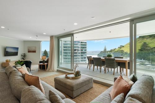 a living room with a couch and a table at Executive Oceanside Apartment in Mount Maunganui