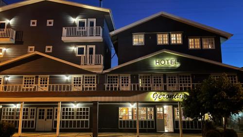 ein Hotelgebäude mit einem Hotelschild bei Nacht in der Unterkunft Hotel Geronimo in Pucón