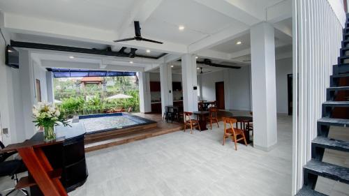 a living room with a pool and a table and chairs at Escotel Majestica in Dalung