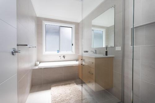 a bathroom with a shower and a sink and a mirror at Casa Azul in Burrill Lake