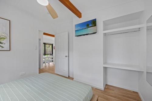 a bedroom with white walls and a bed in a room at Agnes Bush Cabins in Agnes Water