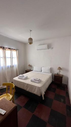 a bedroom with a bed and a table and a chair at Casa Chule in Fiambalá