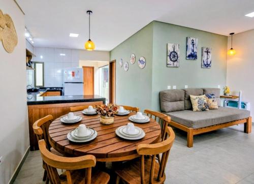 a living room with a wooden table and a couch at Casas Costa Dos Corais - 200m do mar, Climatizada, Confortável e Completa in Japaratinga