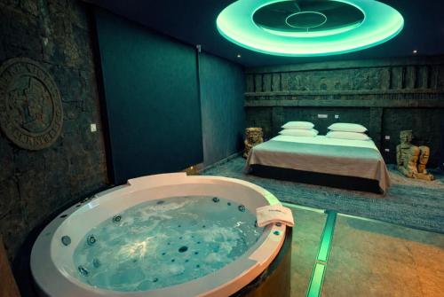 a bath tub in a room with a bed at V Hotel in Arroyomolinos
