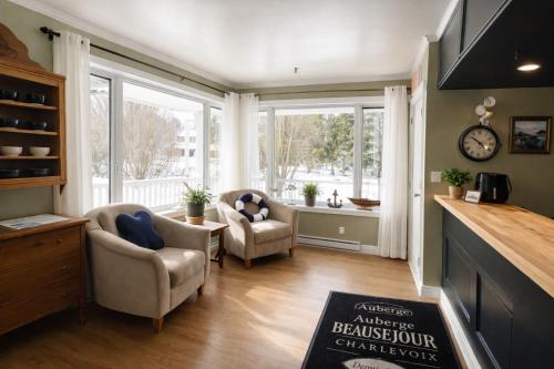 a living room with two chairs and a large window at Auberge Beausejour in Les Éboulements