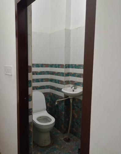 a bathroom with a toilet and a sink at बृजराज गेस्ट हाउस & rooms in Rīngas