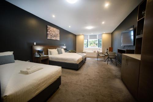 a hotel room with two beds and a television at The Tea Tree in Modbury