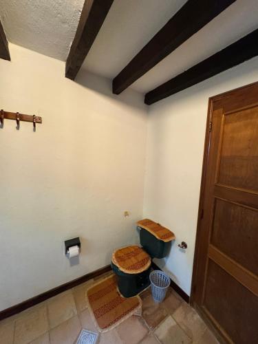 a bathroom with a toilet and a wooden door at Hospedaje Casa Renasiente Cali in Cali