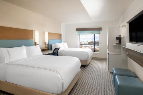 a hotel room with two beds and a flat screen tv at EVEN Hotel Rockville - Washington, DC Area by IHG in Rockville