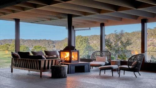 a living room with a fireplace on a patio at Grants - West Cambewarra, Longreach in West Cambewarra