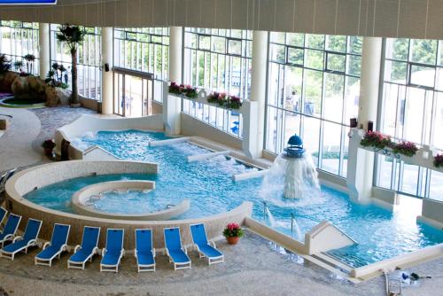 a large pool with chairs and a fountain in a building at Phoenix Resort Pyeongchang in Pyeongchang