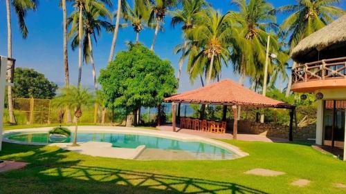 a villa with a swimming pool and a gazebo at Laguinn Hotel Acapulco in Acapulco