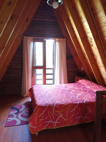 a bedroom with a bed and a large window at Complejo El Tala in Villa la Bolsa