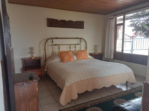 a bedroom with a bed with orange pillows on it at Miravalle Suites in Paipa