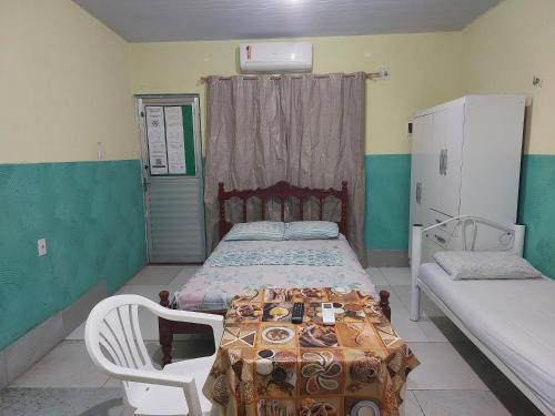 a small bedroom with a bed and a chair at Casa para temporada in Belém