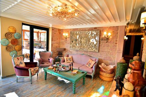 a living room with chairs and a coffee table at Fikretbey Konağı in Ayvalık