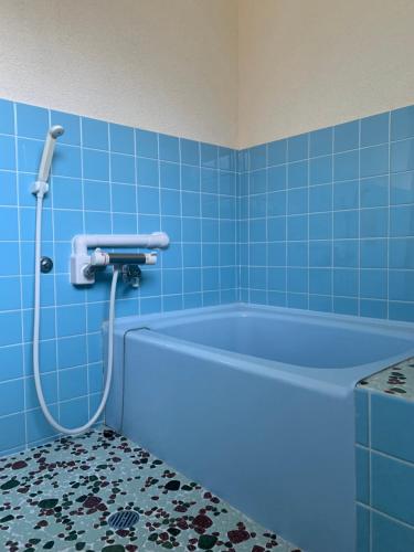 a blue bath tub in a bathroom with blue tiles at 網ノ屋 - Aminoya Beach House Ezura in Shirahama