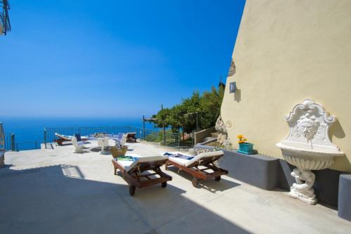 a patio with chairs and the ocean in the background at Casa Lisuccia in Furore