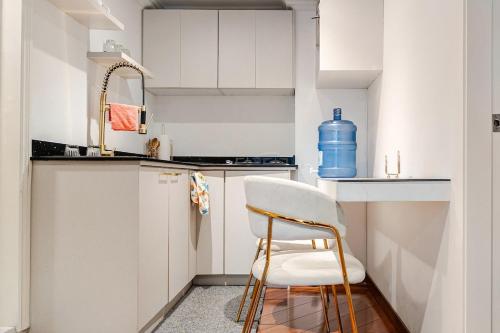 una cucina bianca con una sedia e un lavandino di Lili’s room a Quito