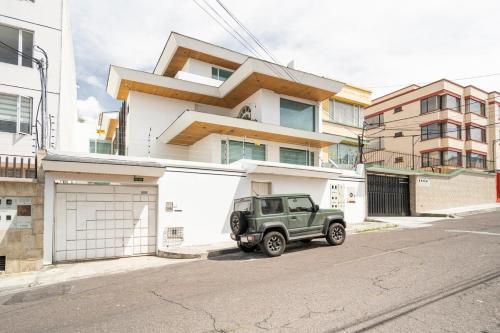 zielony jeep zaparkowany przed budynkiem w obiekcie Lili’s room w mieście Quito