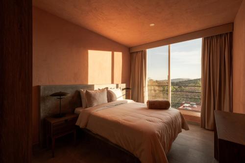 a bedroom with a bed and a large window at Casa Maja Villas Chapala in Chapala