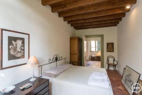 - une chambre avec un lit blanc et un plafond en bois dans l'établissement Casa Gerardi, à Lonato