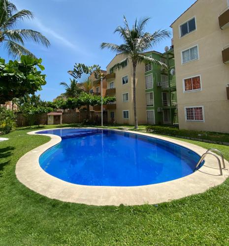 a large blue swimming pool in front of a building at Departamento en Acapulco Diamante planta baja in La Sabana