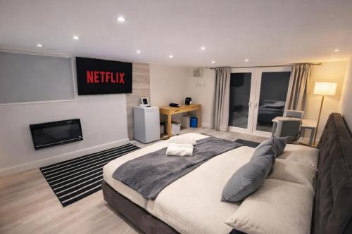 a bedroom with a large bed and a tv at Modern Guest house with private entrance in Manchester