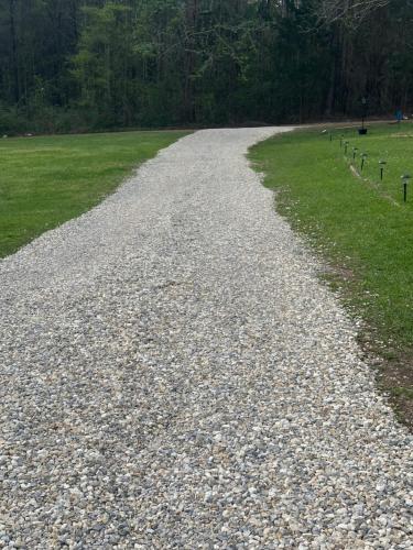 a gravel road in a field with grass at RV Sites at Off the Road Oasis in Lufkin